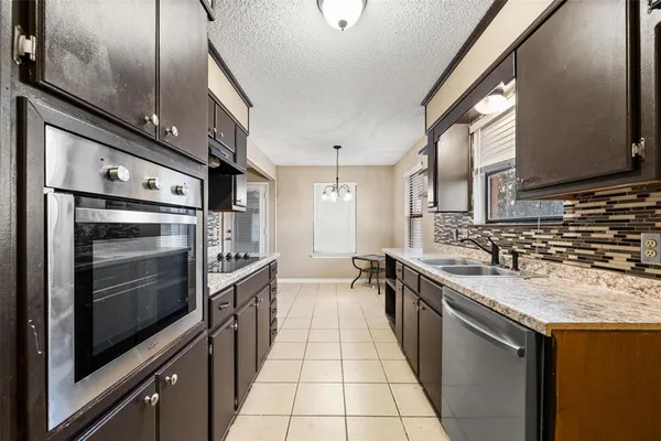 a kitchen with stainless steel appliances granite countertop a sink and a stove