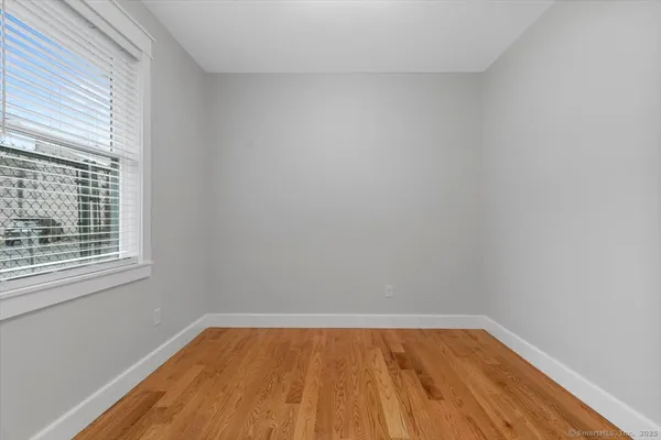 a view of a room with wooden floor and a window