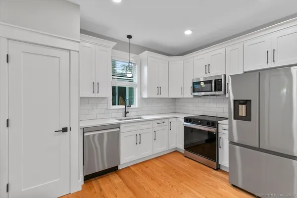 a kitchen with white cabinets stainless steel appliances and sink