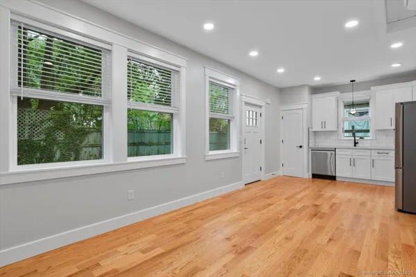 a view of an empty room with a window and wooden floor