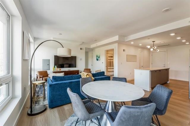 401 Jackson Street, Unit 503 Hoboken, NJ 07030 - Photo 13 of 29 a living room with furniture a flat screen tv and kitchen view