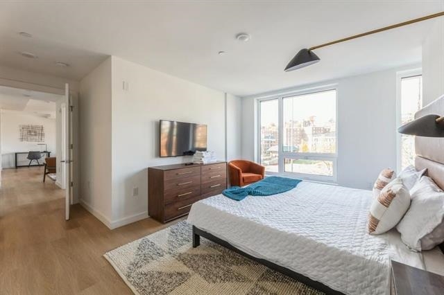 401 Jackson Street, Unit 503 Hoboken, NJ 07030 - Photo 19 of 29 a bedroom with a bed and wooden floor
