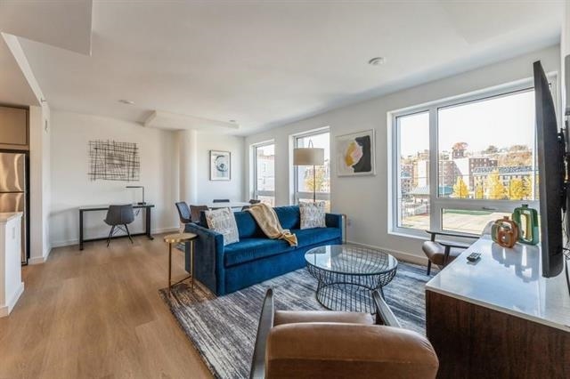 401 Jackson Street, Unit 503 Hoboken, NJ 07030 - Photo 10 of 29 a living room with furniture and a large window