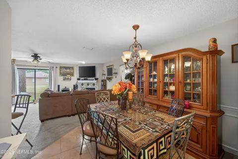 a living room with furniture a chandelier and a flat screen tv