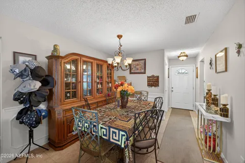 a view of a dining room with furniture and chandelier