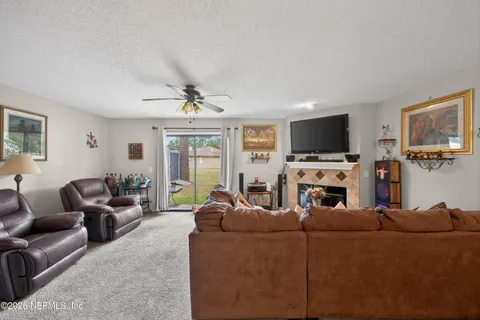 a living room with furniture a fireplace and a flat screen tv