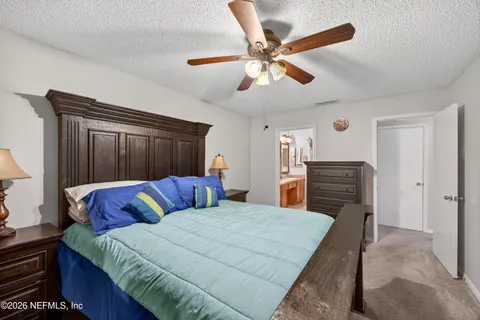 a bedroom with a large bed and a chandelier