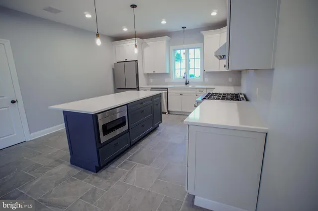 a kitchen with a sink a stove and a refrigerator