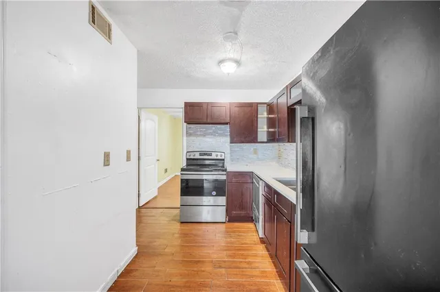 a kitchen with stainless steel appliances granite countertop a refrigerator and a stove