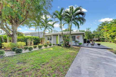 a view of a house with a yard and potted plants