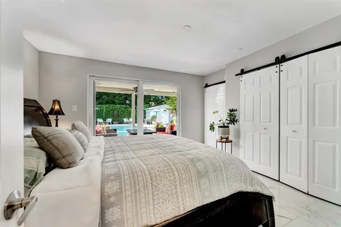 a bedroom with a bed and a large window