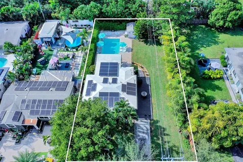 an aerial view of a house with a yard and large trees