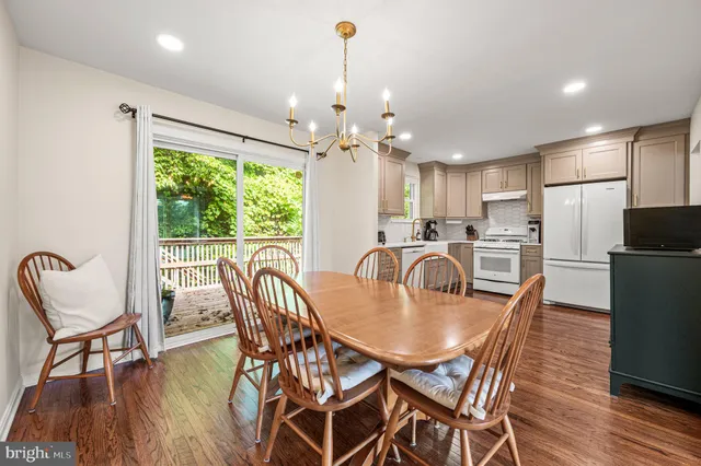 a dining room with furniture a chandelier and wooden floor