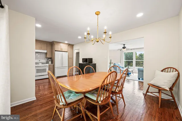 a dining room with furniture a chandelier and wooden floor