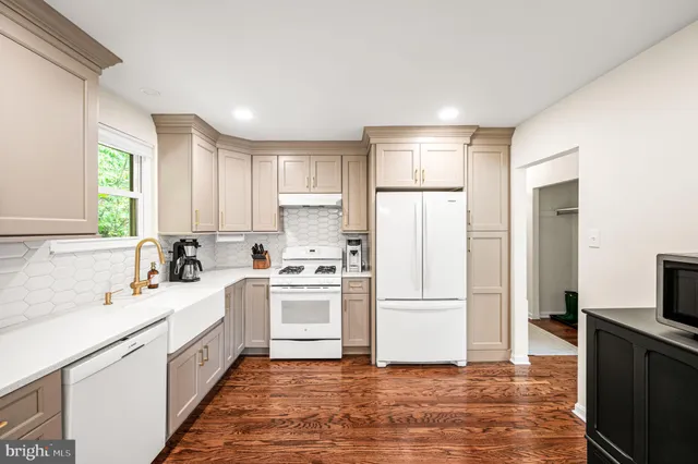 a kitchen with white cabinets and white appliances
