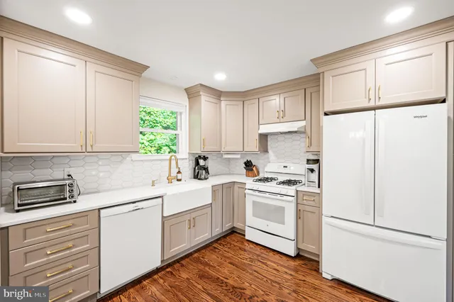 a kitchen with white cabinets and white appliances