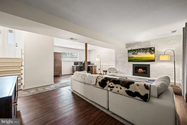 a living room with furniture fireplace and wooden floor