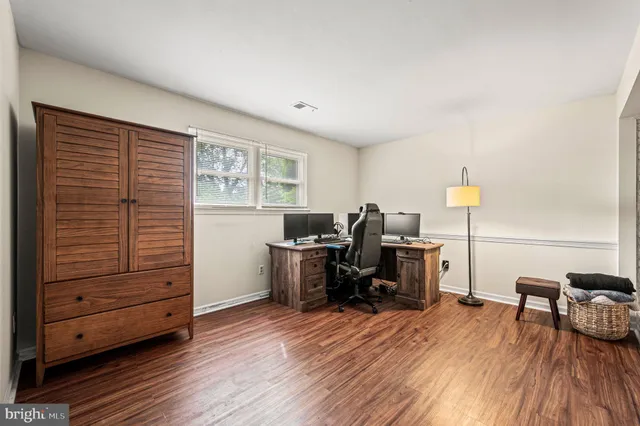 a view of a workspace with furniture and a window