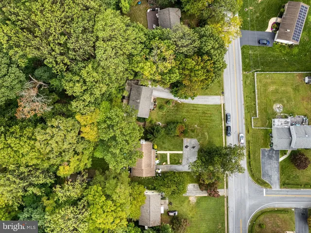 an aerial view of residential houses with outdoor space and trees