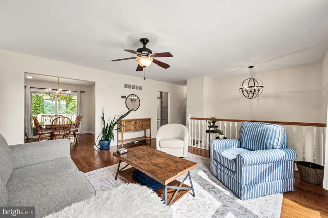 a living room with furniture ceiling fan and a window