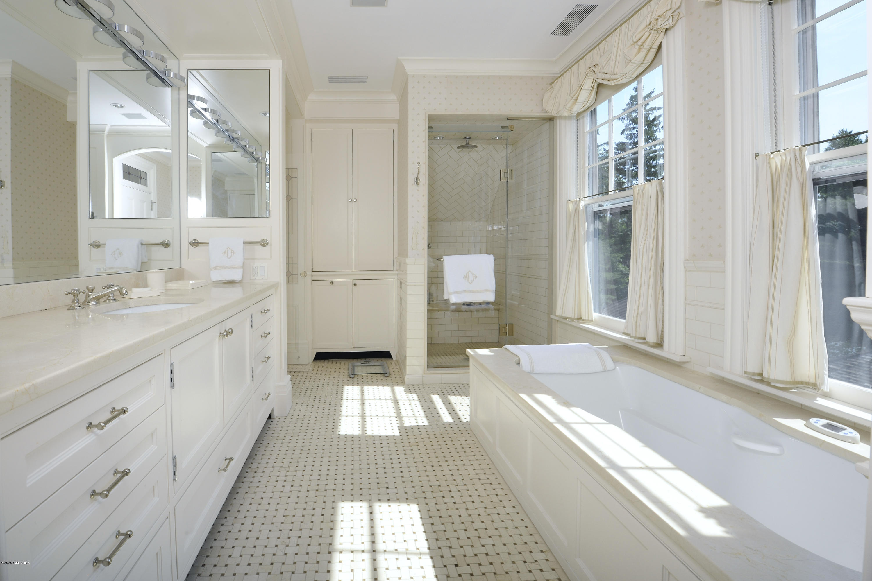 134 Otter Rock Drive Greenwich, CT 06830 - Photo 15 of 25 a spacious bathroom with a double vanity sink a large mirror and a bathtub