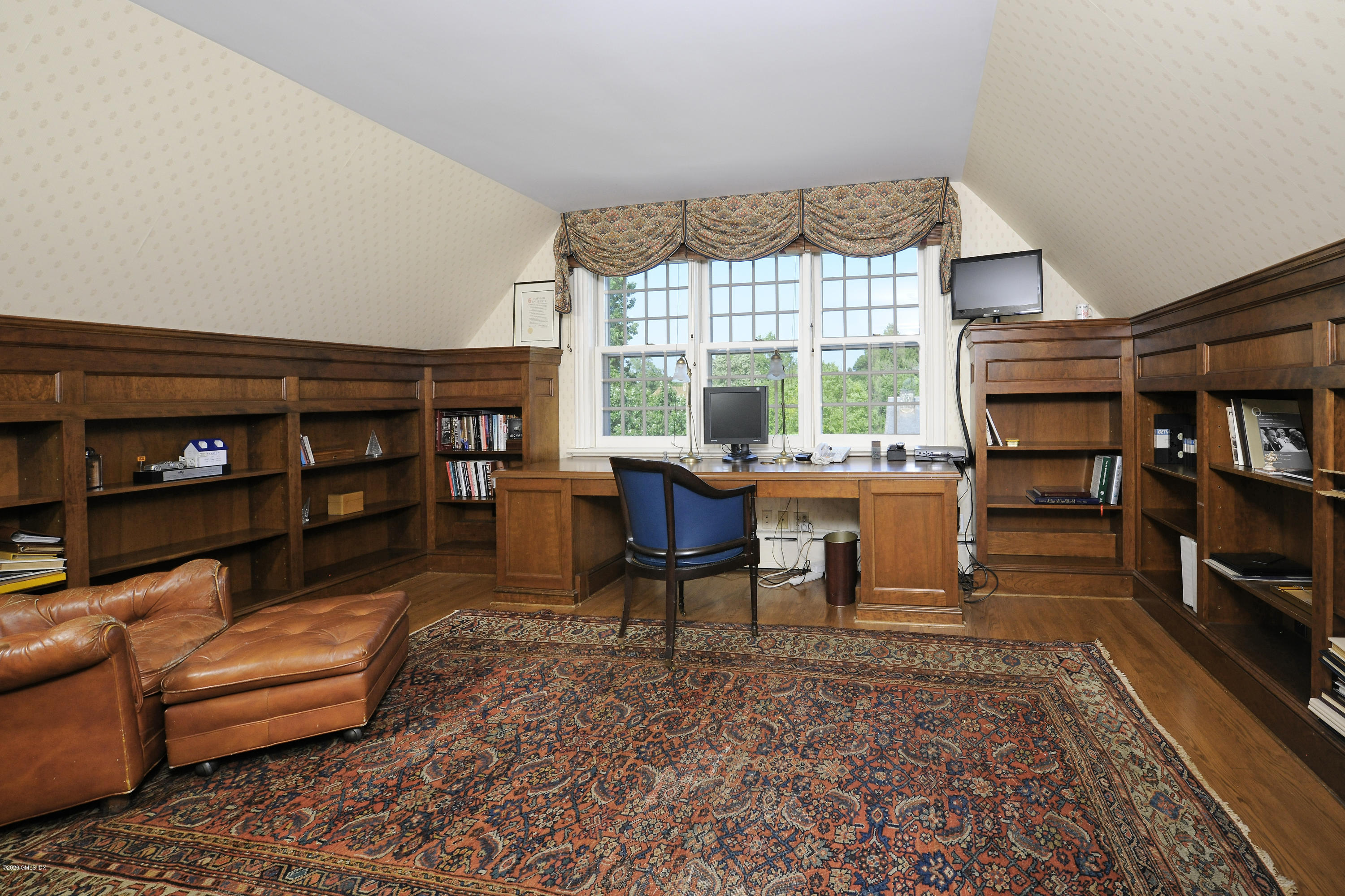 134 Otter Rock Drive Greenwich, CT 06830 - Photo 20 of 25 a living room with furniture a bookshelf and a window