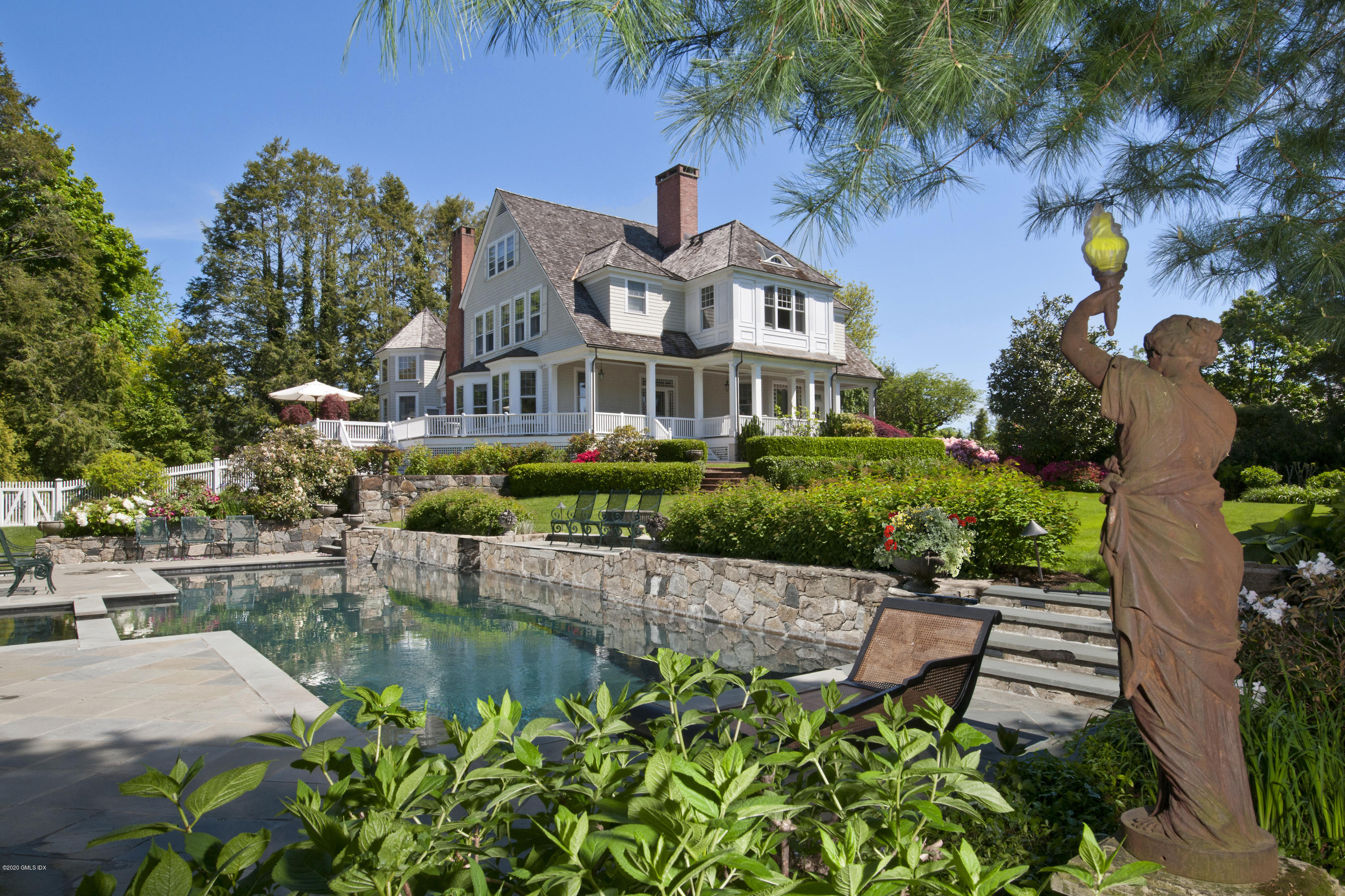 134 Otter Rock Drive Greenwich, CT 06830 - Photo 25 of 25 a front view of a house with a garden and sitting area