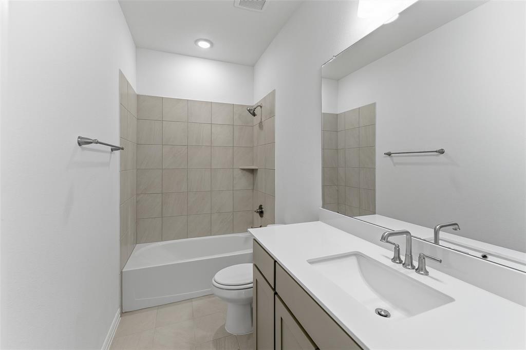 130 Fossil Canyon Drive Rhome, TX 76078 - Photo 14 of 25 Contemporary bathroom featuring a combined tub and shower with tile surround and built-in niche