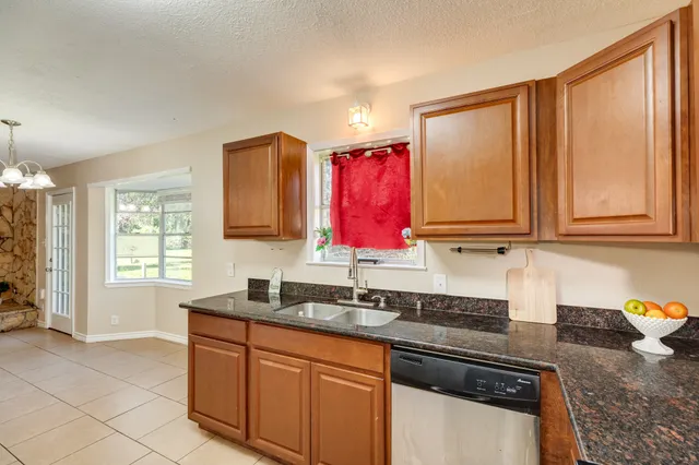 a kitchen with stainless steel appliances granite countertop a sink stove and cabinets