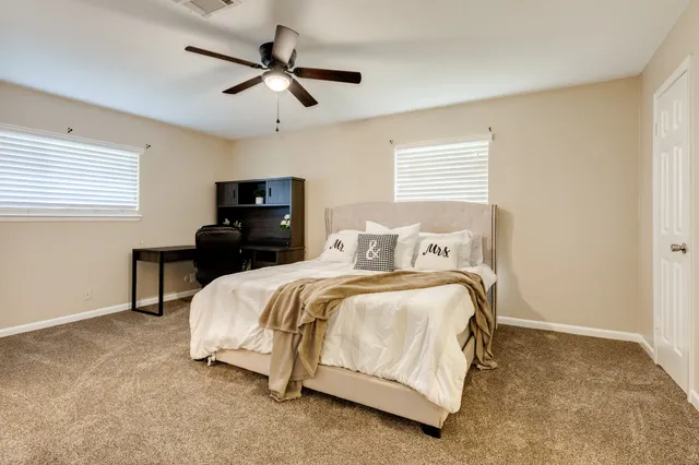 a spacious bedroom with a bed and a chandelier