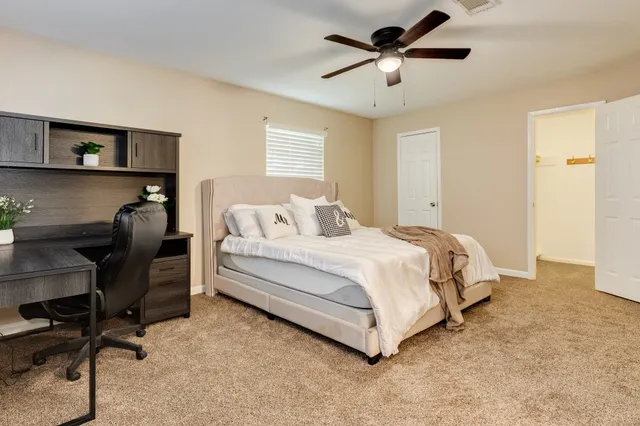 a bedroom with a bed a chair and a chandelier