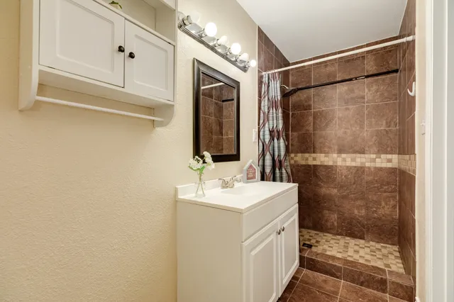 a bathroom with a sink mirror and shower