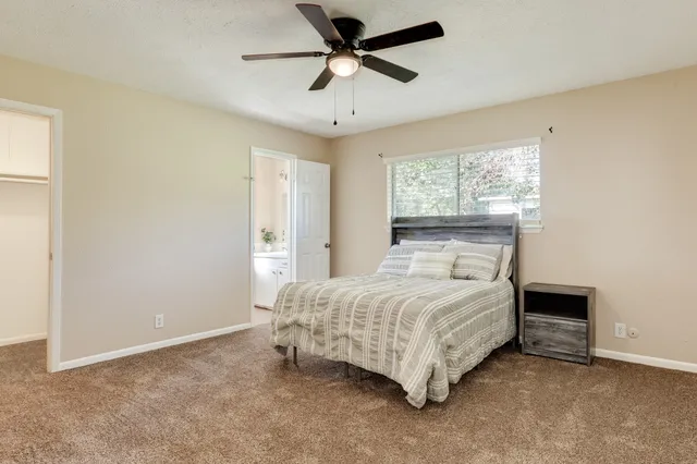 a bedroom with a bed chandelier and a window