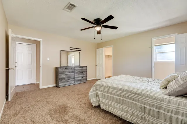 a bedroom with a bed and ceiling fan