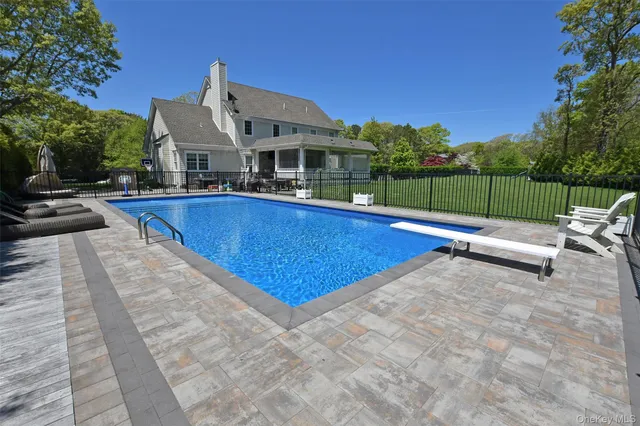 a view of a house with pool and a yard