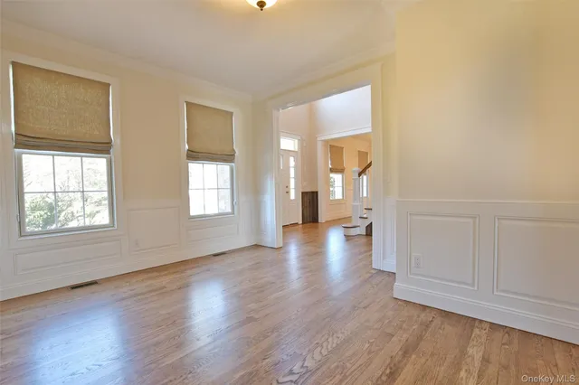 an empty room with wooden floor and a window