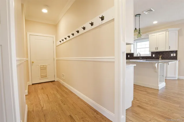 a kitchen with granite countertop a refrigerator a sink and wooden floor
