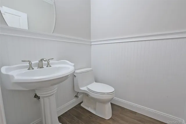 a bathroom with a sink toilet and a mirror