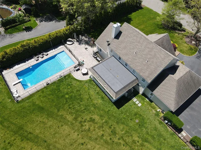 an aerial view of a house with backyard space and balcony
