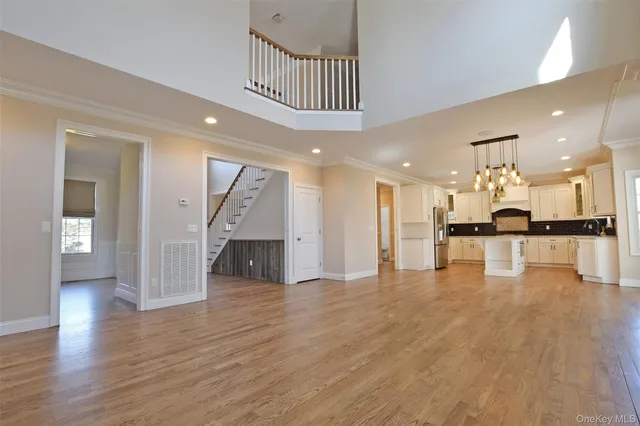 a view of a hallway with wooden floor and a kitchen
