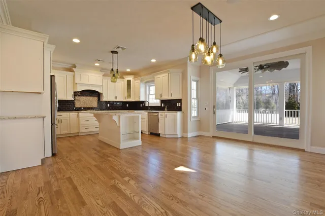 a view of large kitchen with refrigerator and wooden floor