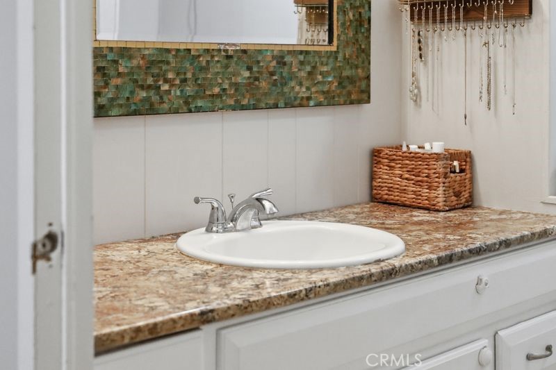 34164 Harrow Hill Road Wildomar, CA 92595 - Photo 22 of 60 a bathroom with a granite countertop sink and a mirror
