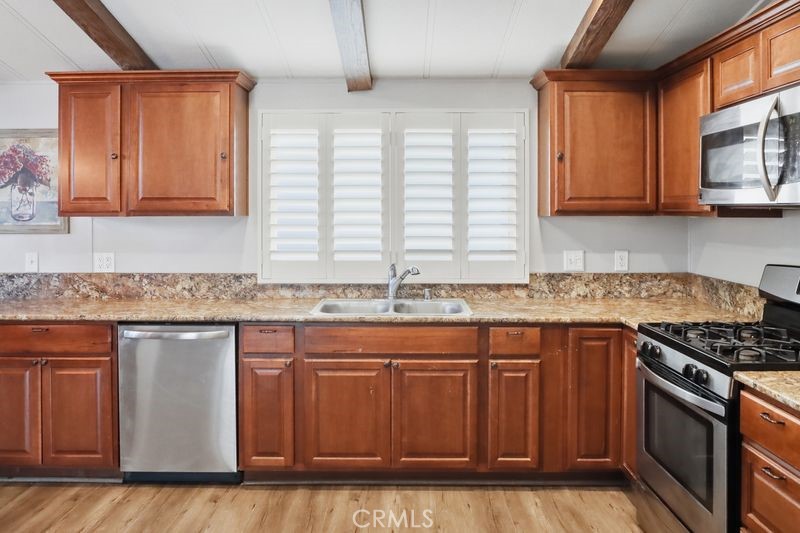34164 Harrow Hill Road Wildomar, CA 92595 - Photo 5 of 60 a kitchen with granite countertop a sink stove and cabinets