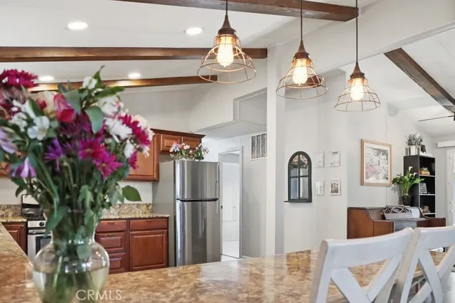 a dining room with stainless steel appliances furniture a chandelier and a rug
