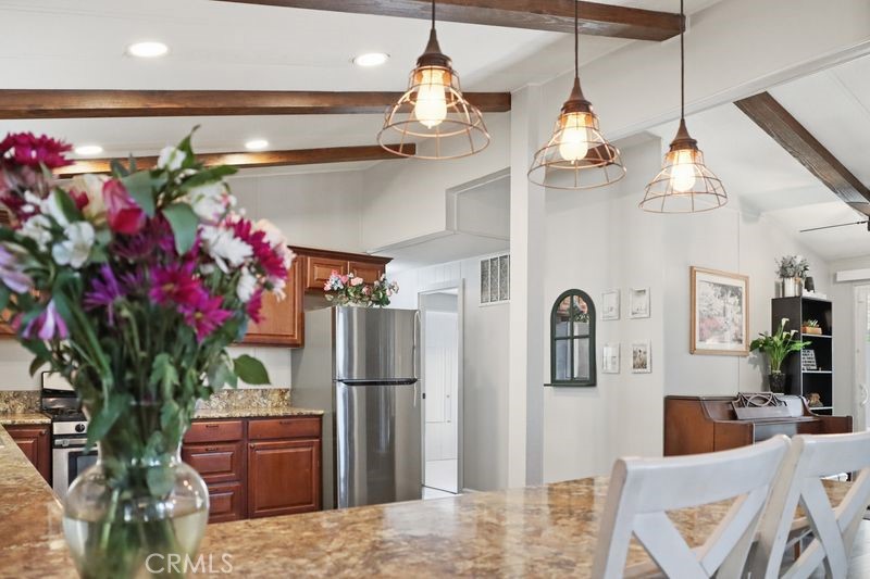 34164 Harrow Hill Road Wildomar, CA 92595 - Photo 7 of 60 a dining room with stainless steel appliances furniture a chandelier and a rug