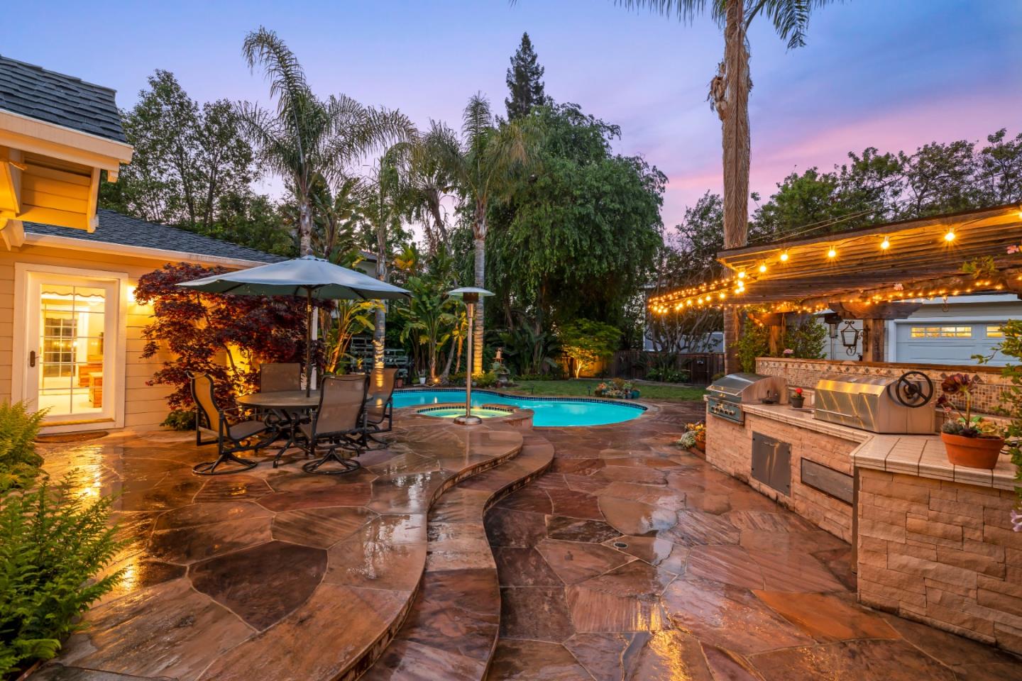 261 Cherry Lane Campbell, CA 95008 - Photo 2 of 49 a view of a patio with a table and chairs under an umbrella with palm trees