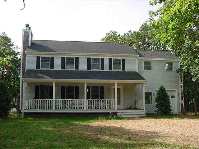 6 Farm Path Road Edgartown, MA 02539 - Photo 1 of 14 a view of a brick house with a large windows and a yard with plants and large trees