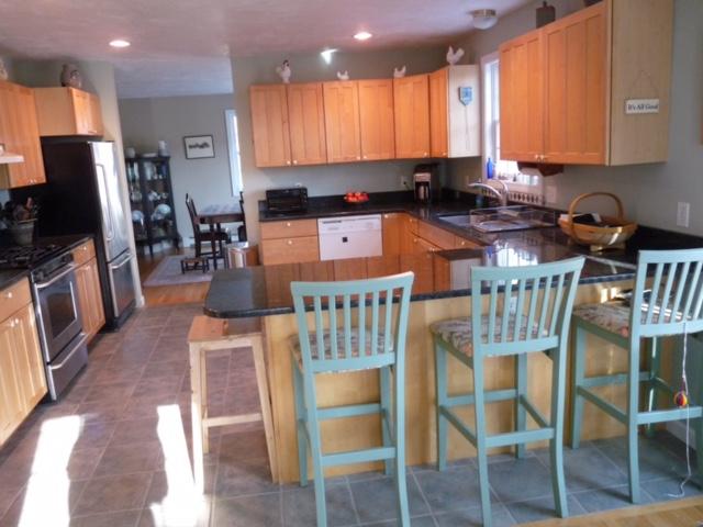 6 Farm Path Road Edgartown, MA 02539 - Photo 5 of 14 a kitchen with stainless steel appliances granite countertop a stove top oven a sink a dining table and chairs