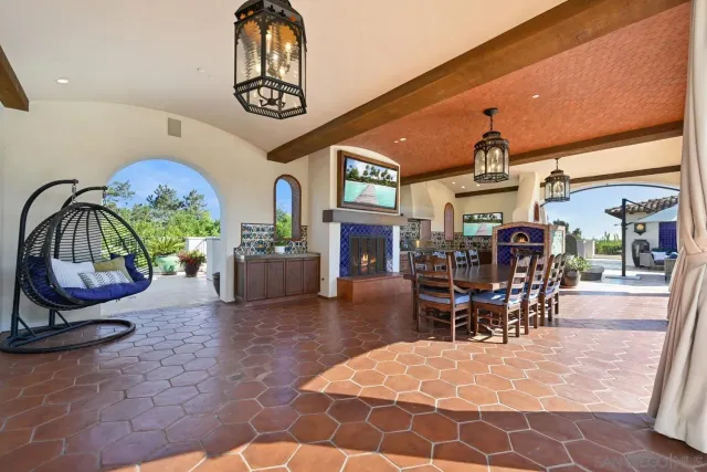 a view of a dining room and livingroom with furniture wooden floor a rug a painting and a chandelier