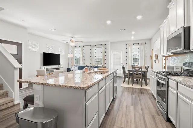 a kitchen with stainless steel appliances granite countertop a sink stove and microwave